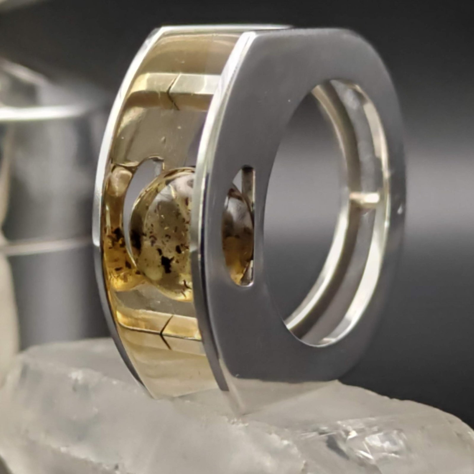 Silver and amber suspension ring where the gemstone is suspended between two sterling silver planes